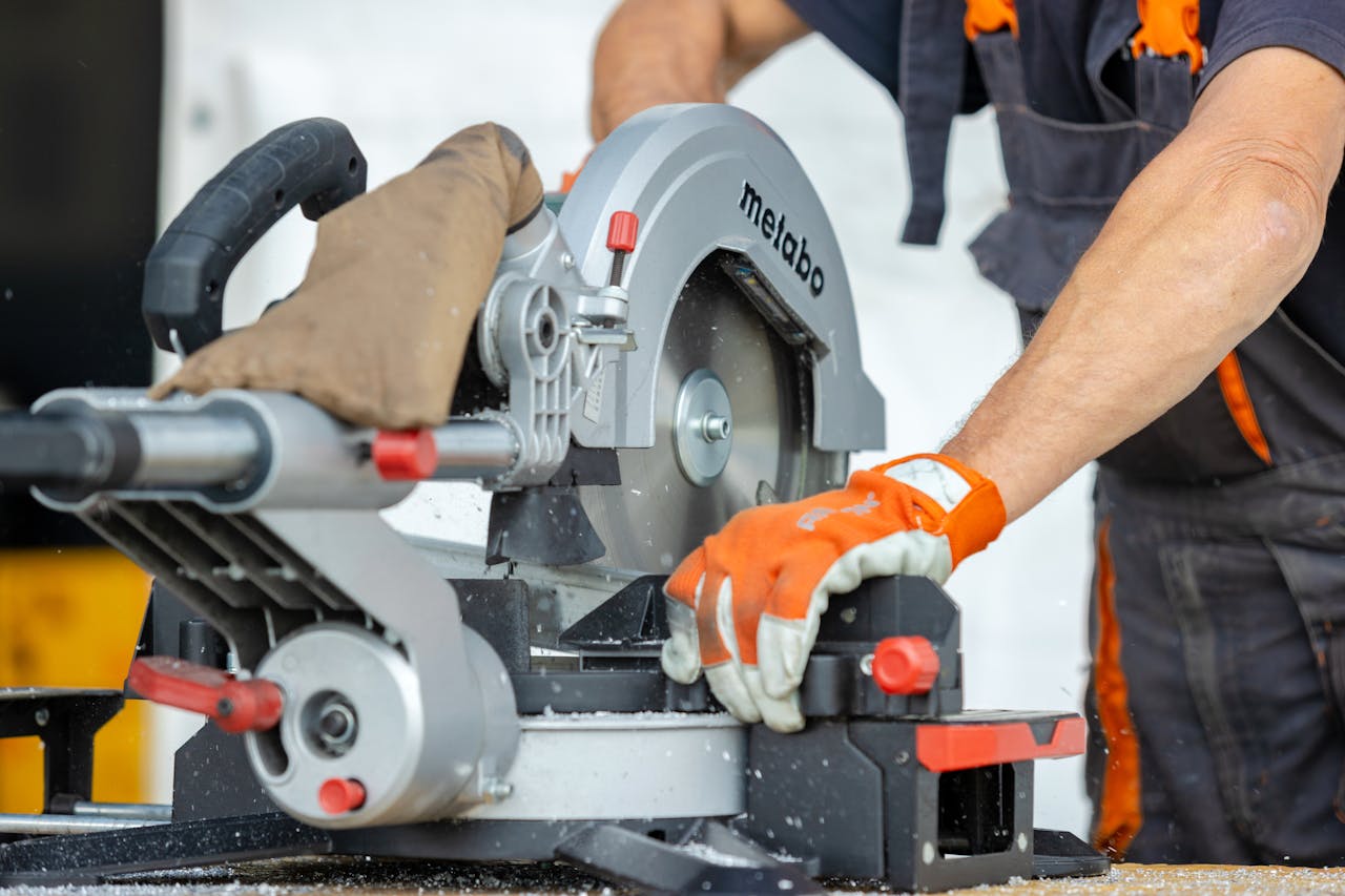 about-02 Focused worker using a metal saw for precise cutting at a construction site.